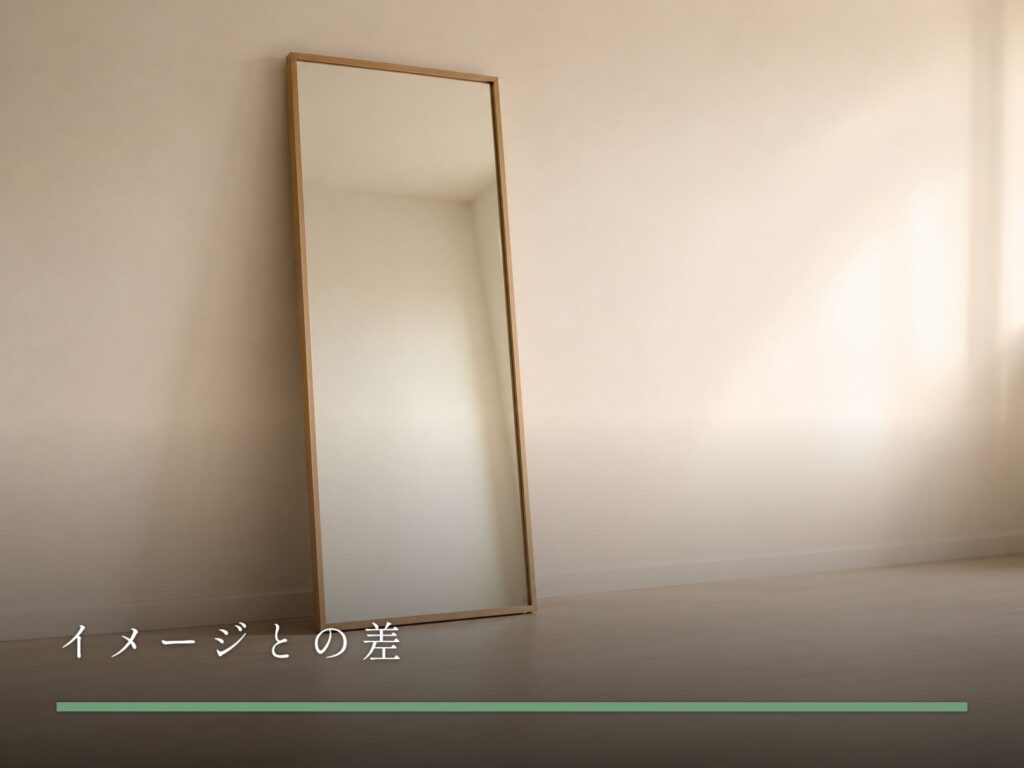 壁に立てかけられた大きな鏡に、部屋のやわらかい光だけが映っている（イメージとの差）