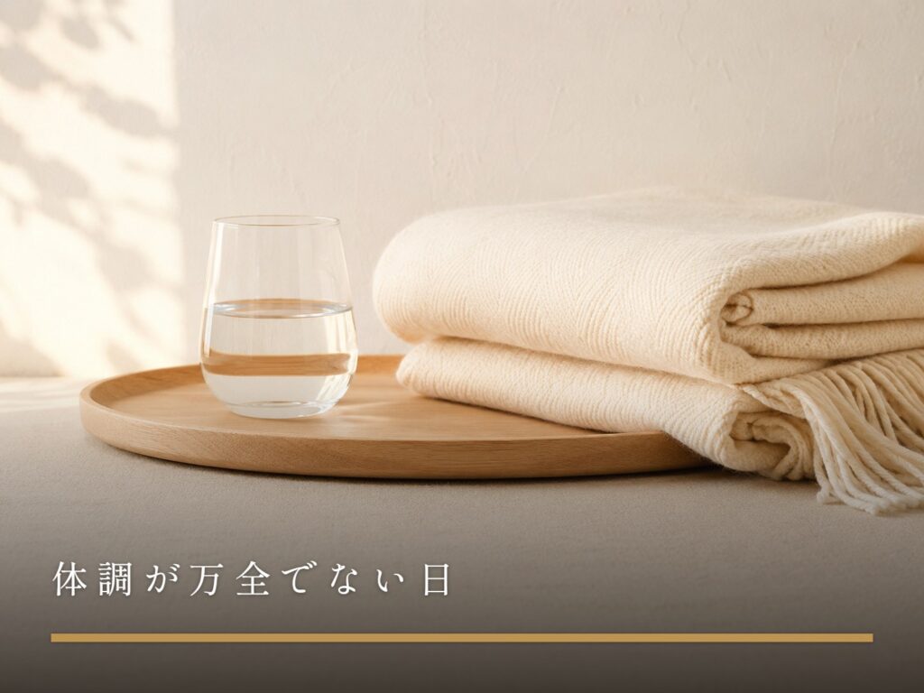 木のトレイに置かれた水のグラスと、たたまれたブランケット（体調が万全でない日）