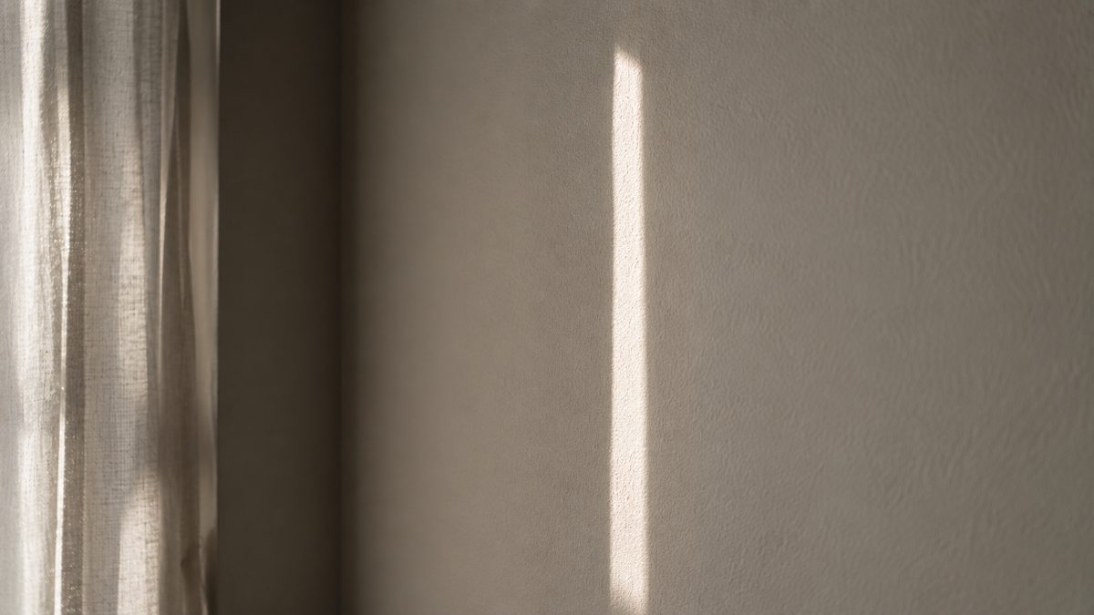 白い壁に落ちた、一本の細い光の帯
