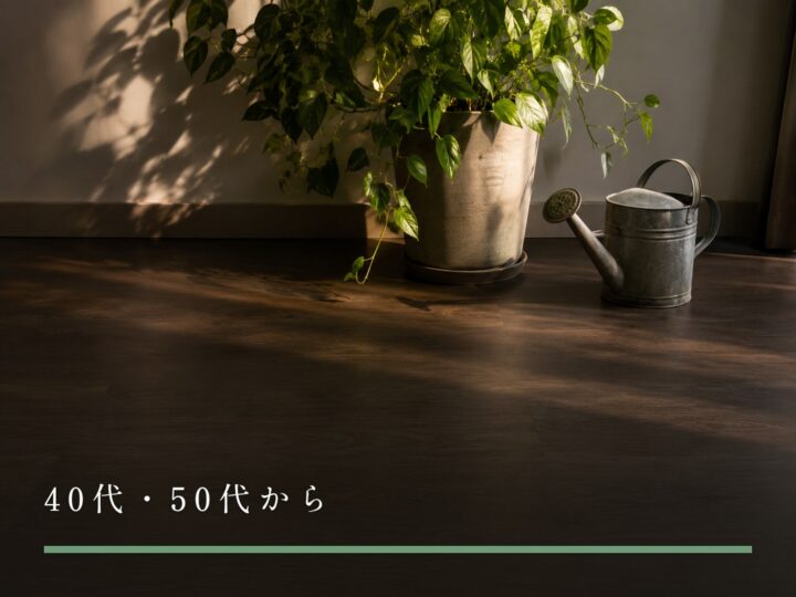 部屋の床に置かれた観葉植物の鉢と、使い込まれた金属のじょうろ（40代・50代から）