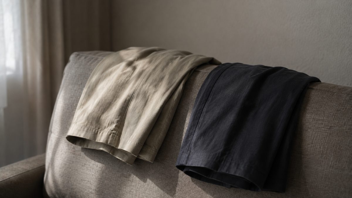ソファの背に並べて掛けられた、二枚のたたんだ上着