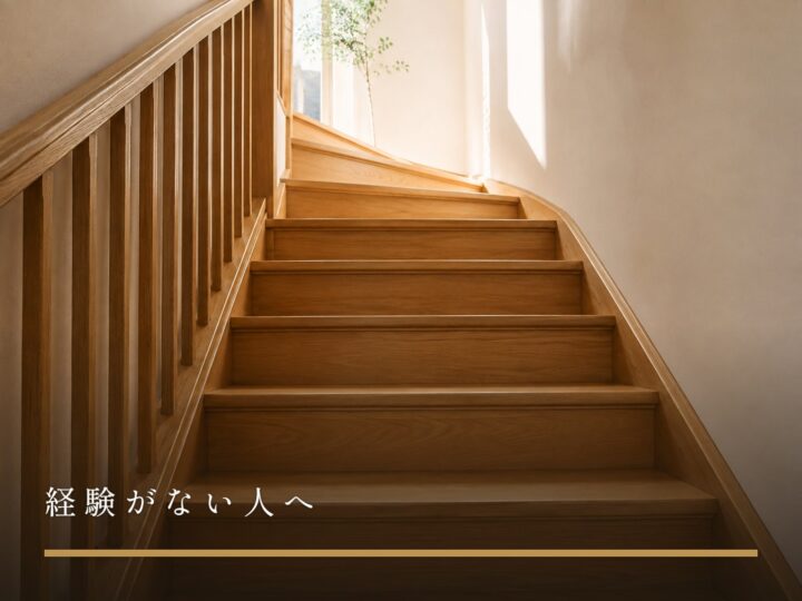 室内の木の階段を下から見上げた構図。下の数段だけが見えている（経験がない人へ）