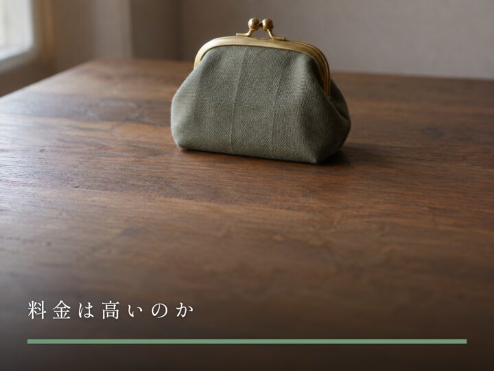 木の台に置かれた、口金を閉じた布のがま口(料金は高いのか)
