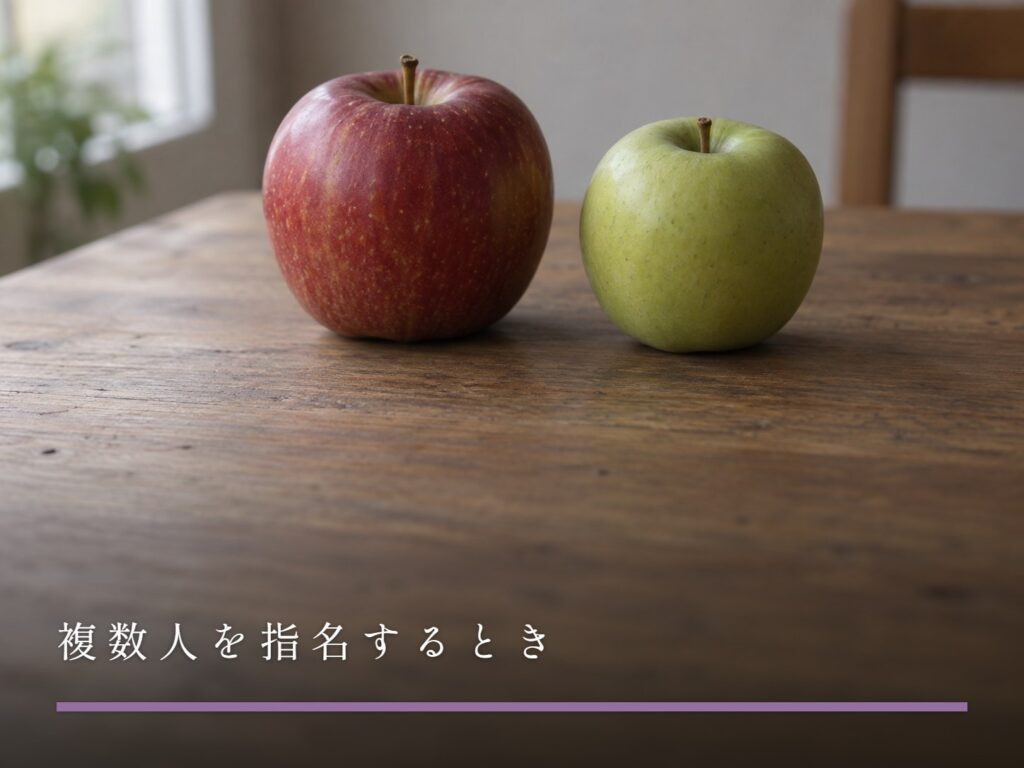木の台に並べて置かれた、色の違う二つのりんご（複数人を指名するとき）