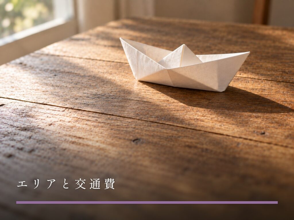 木の机に置かれた、白い紙で折った小さな舟（エリアと交通費）