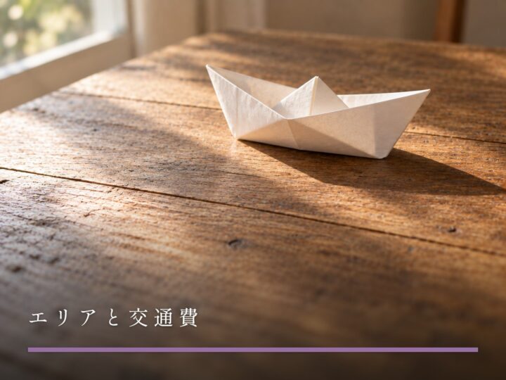 木の机に置かれた、白い紙で折った小さな舟（エリアと交通費）