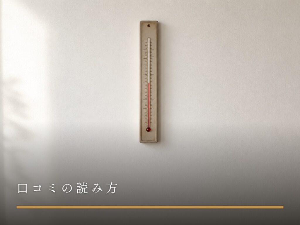 白い壁に掛かった、細長いアナログ温度計（女風の口コミの読み方）