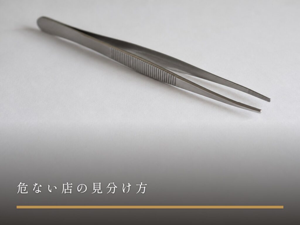 白い紙の上に置かれた、先が少し開いた柄の長い金属のピンセット（危ない店の見分け方）