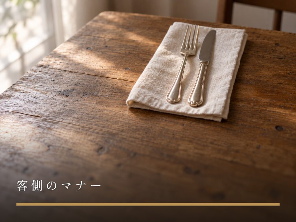 白い布ナプキンの上にそろえて置かれた、銀のフォークとナイフ（客側のマナー）